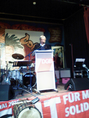Bild: Auf dem Podium: Wolf-Dietrich Glaser, ehrenamtlicher DGB-Vorsitzender Pforzheim/Enzkreis (Foto: R.Neff)