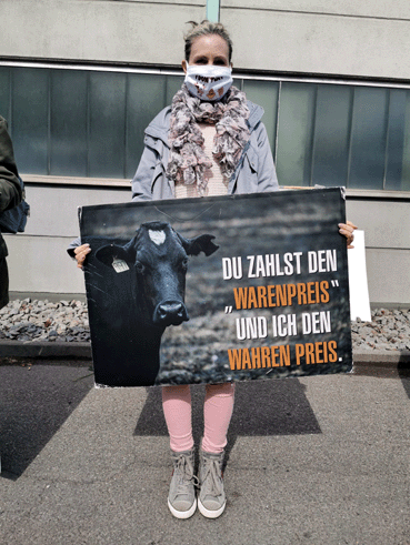 Bild: Aktivistin demonstriert vor Fleisch-Müller mit Plakat